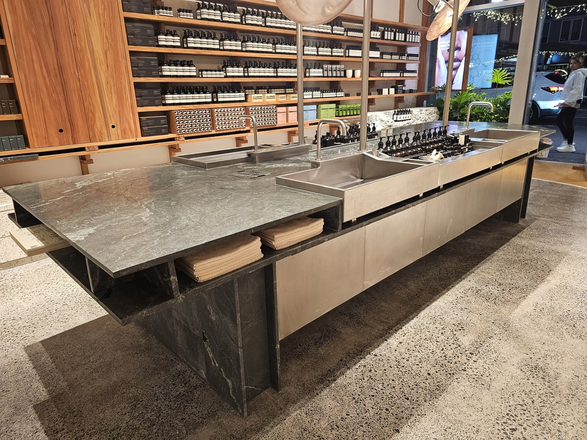 Custom stone retail counter with integrated basins, fabricated by Stone Living